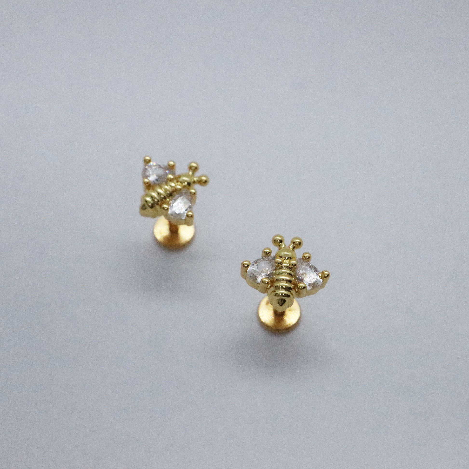 Dainty gold stud earrings with gemstone bee design