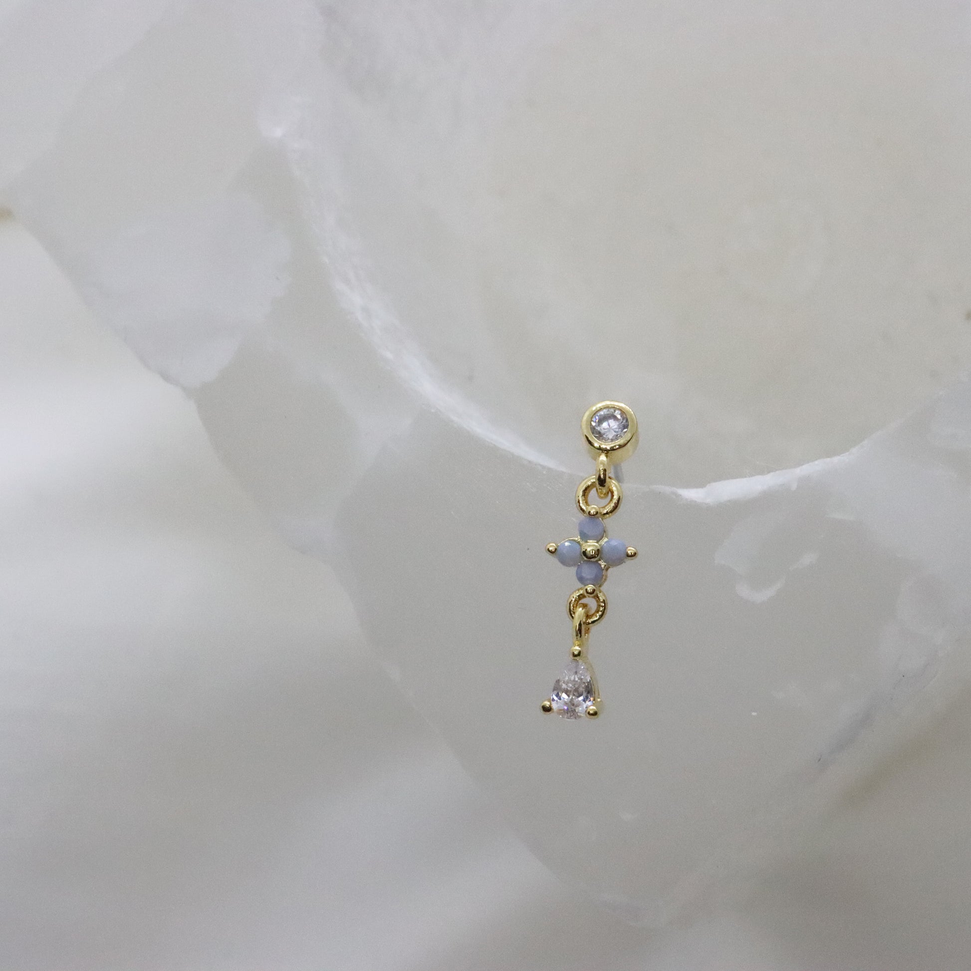 Minimalist gold earring with a flower design and gemstone detail